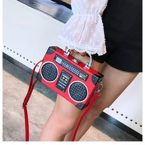 Détail d'un sac à main rouge créatif en forme de radio avec poignées et bandoulière