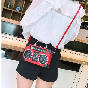 Vue détaillée d'un sac bandoulière rouge en forme de radio rétro avec poignées métal