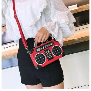 Détail du sac à main rouge en forme de radio vintage avec poignée en métal robuste