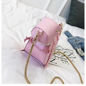 Detailansicht der pinken Dinosaurier-Tasche mit goldenen Nieten und Metallkette