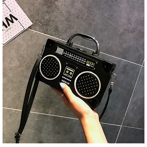 Gros plan du sac à main rétro en forme de radio noire avec poignée en métal et détails