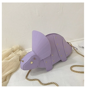 Détail du sac dinosaure lavande avec rivets dorés et bandoulière en chaîne métallique