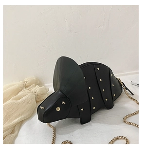 Détail du sac dinosaure noir avec rivets dorés et bandoulière en chaîne serpent