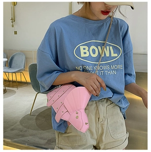 Détail du sac tricératops rose avec rivets dorés et bandoulière sur le mannequin
