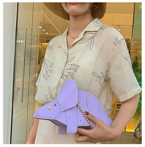 Détail du sac à bandoulière tricératops violet avec clous dorés et chaîne en métal