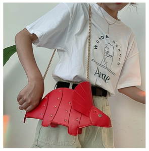 Détail du sac bandoulière dinosaure rouge avec rivets dorés et bandoulière chaîne