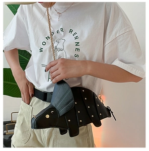 Détails du sac dinosaure noir avec rivets dorés et bandoulière en chaîne