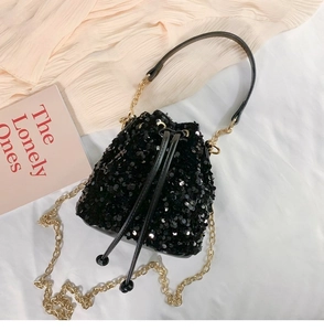 Detail of black sequined bucket bag with gold chain strap and drawstring closure