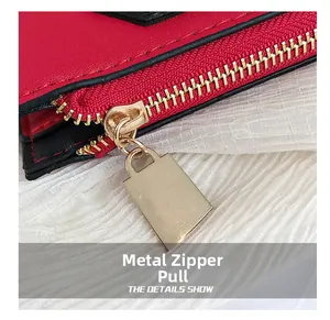 Détail de la fermeture éclair en métal doré sur un sac en cuir texturé rouge