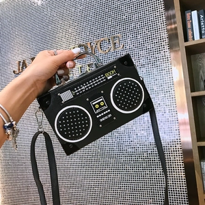 Sac à main noir en forme de radio rétro avec poignée argentée et détails graphiques