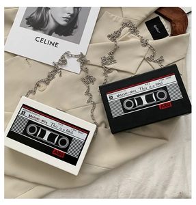 Détail d'un sac bandoulière créatif en forme de cassette avec grosse chaîne en métal argenté
