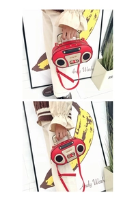 Detail der roten Retro-Radio-Handtasche mit dekorativen Nieten und elegantem Griff