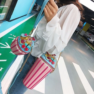 Detail of creative ice cream crossbody bag featuring pink stripes and cherry embroidery