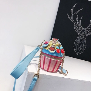 Close-up of cupcake-shaped crossbody bag with pink stripes and gold chain strap