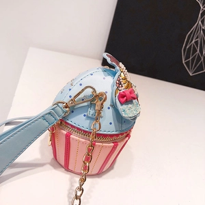 Close-up of creative cupcake-shaped handbag featuring blue polka dots and a golden chain
