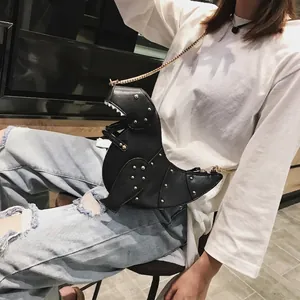 Süße schwarze Dinosaurier Umhängetasche mit Goldnieten und Metallkette am Modell