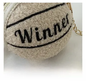 Dettaglio macro della borsa basket in pile beige con ricamo Winner e catena dorata