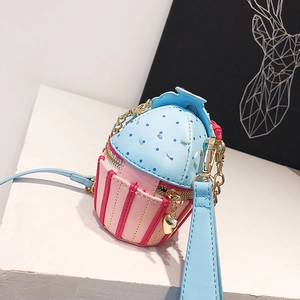 Detailed macro view of heart zipper pull and golden chain on cupcake crossbody bag