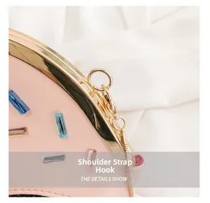 Detail of pink leather bag featuring colorful gemstones and gold-tone hardware hooks