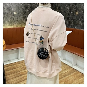 Dettaglio di una mini borsa rotonda da basket con scritta Winner e catena oro