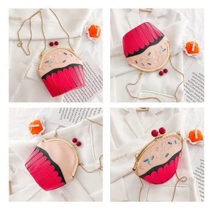Detail view of pink cupcake crossbody bag with gold chain and cherry closure