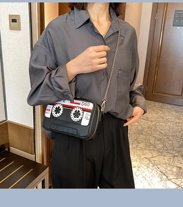 Retro cassette tape crossbody bag with gold chain strap shown on person in lifestyle scene