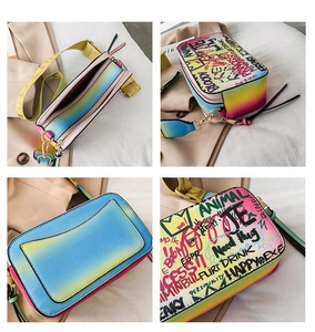 Detail showing rainbow gradient texture and bold street style graffiti on camera bag