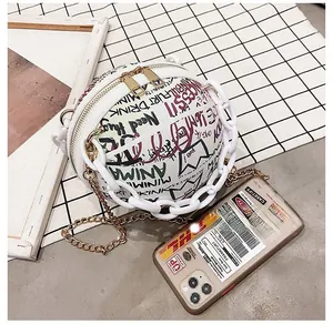 Detail of spherical PU leather bag with graffiti art and chunky white plastic chain