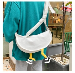 Dettaglio della borsa a tracolla in tela bianca con zampe di anatra in peluche 3D