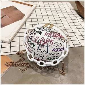 Top view of a round graffiti shoulder bag with white chunky chain and gold metal strap