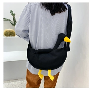 Borsa a tracolla in tela nera con testa e zampe di anatra 3D indossata da una modella
