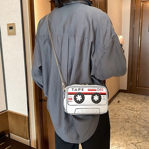 Retro cassette tape design crossbody bag with gold chain strap worn by a model