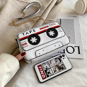 Retro cassette tape crossbody bag in white PU leather with gold chain on cozy background