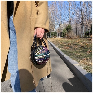 Detail of creative basketball-shaped crossbody bag with graffiti print and chain strap
