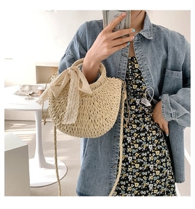 Detailed shot of beige straw handbag with lace bow and woven shoulder strap for women