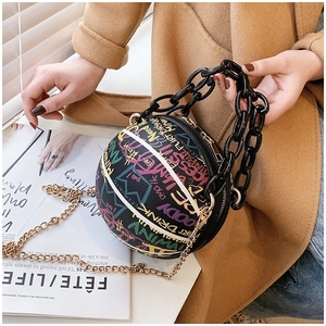 Detail of creative basketball-shaped purse with colorful graffiti and dual chain straps