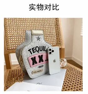 Detail of silver sequined tequila bottle bag with gold chain and phone size reference