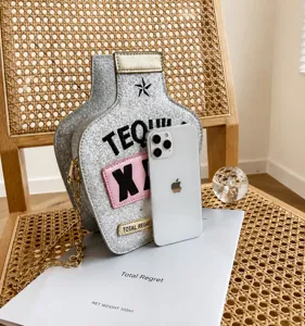 Détail du sac bouteille tequila à paillettes argentées avec chaîne dorée et téléphone
