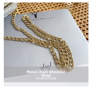 Detailed close-up of golden metal chain strap on a silver sequin bottle-shaped shoulder bag