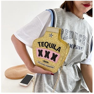 Close-up of golden sequin tequila bottle shaped crossbody bag with metallic chain strap