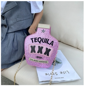 Close-up of pink sequined tequila bottle bag with gold chain on a sofa background