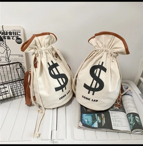 Close-up of canvas drawstring bag with money symbol and brown leather trim details