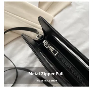 Détail du zip en métal argenté et cuir noir lisse sur un sac à main créatif et amusant