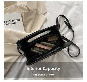 Vue détaillée de la capacité intérieure du sac à bandoulière noir en cuir PU avec objets