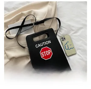 Détail du sac bandoulière créatif Stop montrant la taille par rapport au téléphone