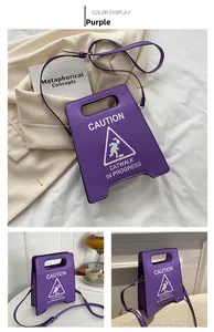 Détail du sac à bandoulière violet créatif en forme de panneau avec texte catwalk