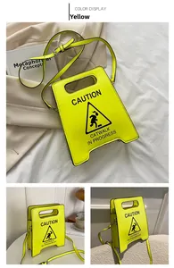 Vue détaillée du sac à main jaune en forme de panneau de signalisation avec bandoulière