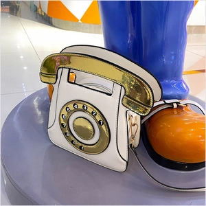 Détail d'un sac téléphone rétro avec cadran doré et pavé numérique détaillé