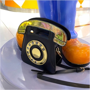 Détail d'un sac bandoulière créatif rétro en forme de téléphone avec accents dorés