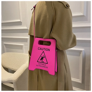 Détail du sac bandoulière rose néon en forme de panneau avec imprimé Caution Catwalk